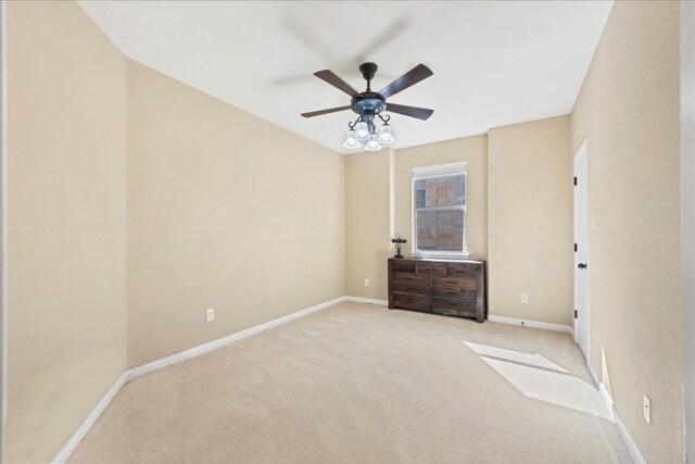 unfurnished bedroom with baseboards, a ceiling fan, and light colored carpet