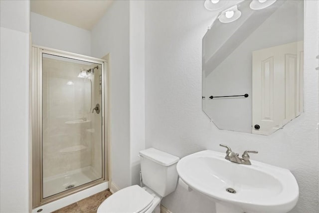 full bathroom with toilet, a stall shower, tile patterned flooring, and a sink