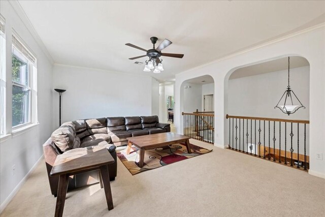 living room with ornamental molding, ceiling fan, and carpet flooring