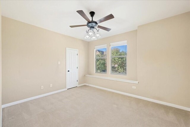 carpeted spare room with ceiling fan