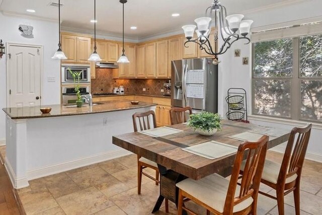 dining space with an inviting chandelier, crown molding, and sink