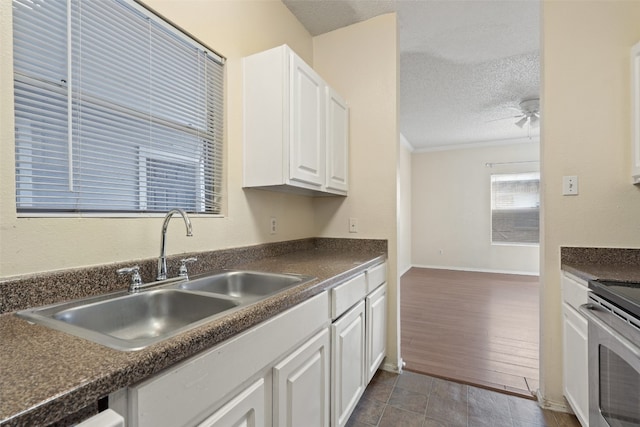 kitchen featuring a textured ceiling, dark hardwood / wood-style floors, sink, white cabinets, and ceiling fan