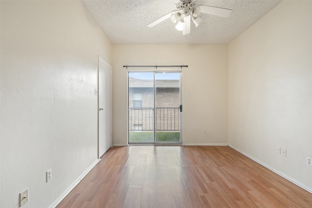 empty room with a wealth of natural light, a textured ceiling, and light hardwood / wood-style floors