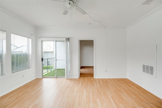 empty room with visible vents, plenty of natural light, and light wood-style floors