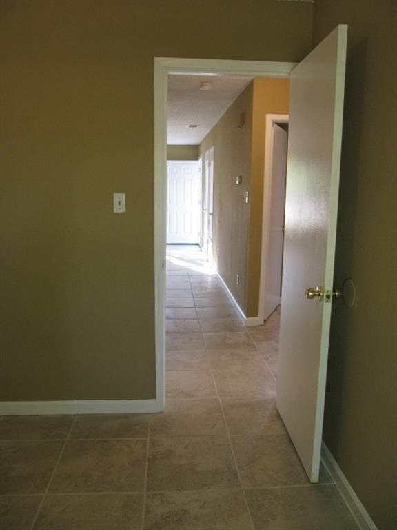 hall featuring light tile patterned floors