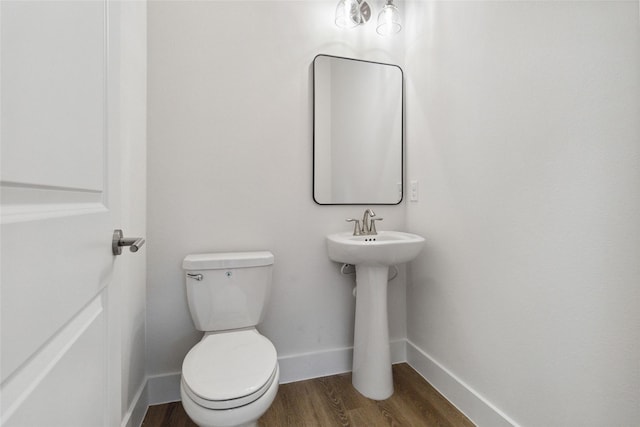 bathroom featuring wood-type flooring and toilet