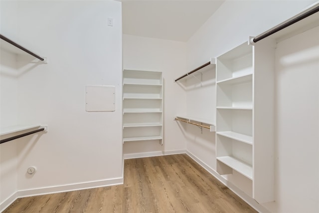 walk in closet with light hardwood / wood-style flooring