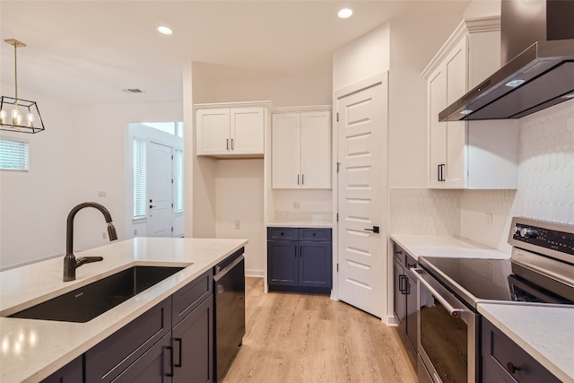 kitchen featuring white cabinets, wall chimney range hood, dishwasher, and stainless steel range oven