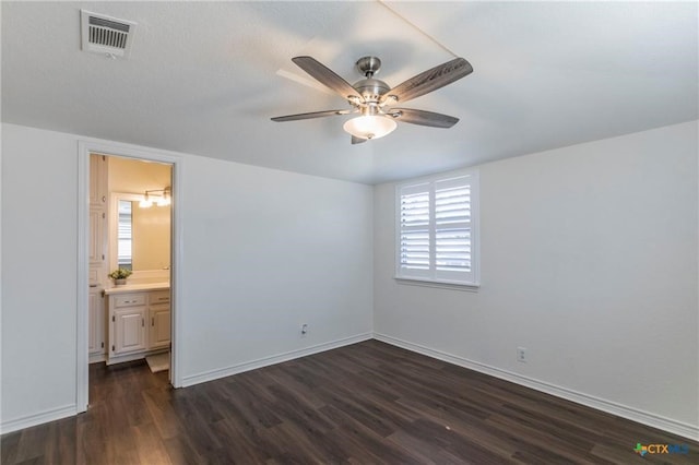 unfurnished bedroom featuring dark wood-type flooring, ceiling fan, and connected bathroom