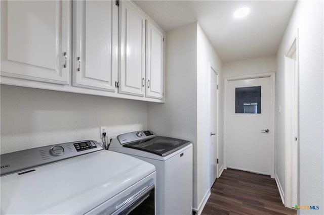 laundry room with dark wood-type flooring, cabinets, and washing machine and clothes dryer