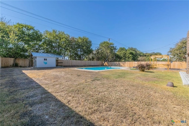 view of yard with a storage shed and a fenced in pool