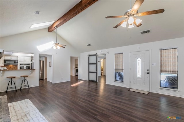 unfurnished living room with dark hardwood / wood-style flooring, a barn door, high vaulted ceiling, ceiling fan, and beam ceiling