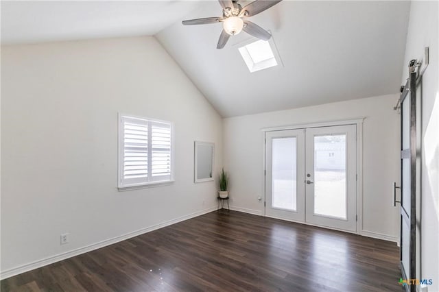 empty room with a barn door, french doors, a skylight, and dark hardwood / wood-style flooring