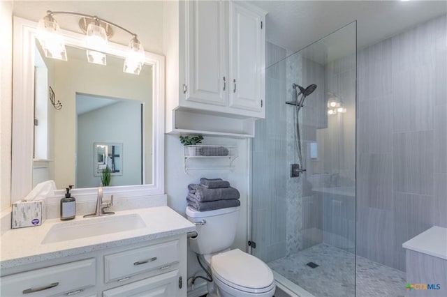 bathroom featuring toilet, vanity, and a shower with shower door