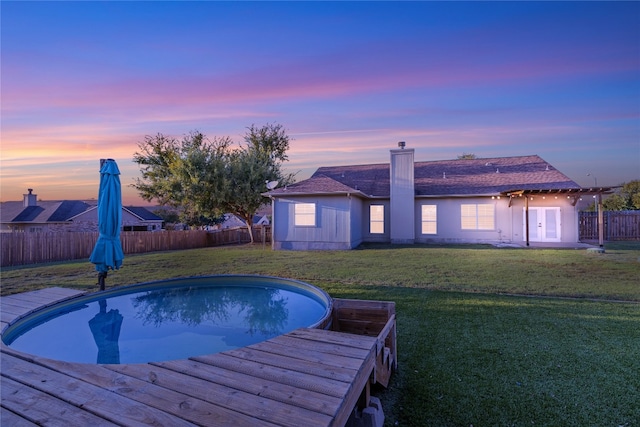 pool at dusk featuring a wooden deck