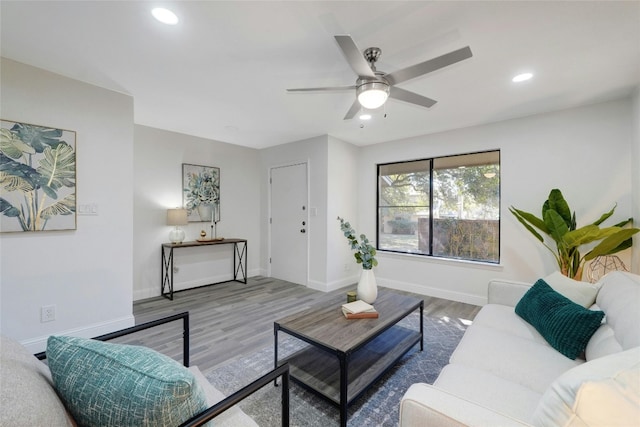 living room featuring wood-type flooring and ceiling fan