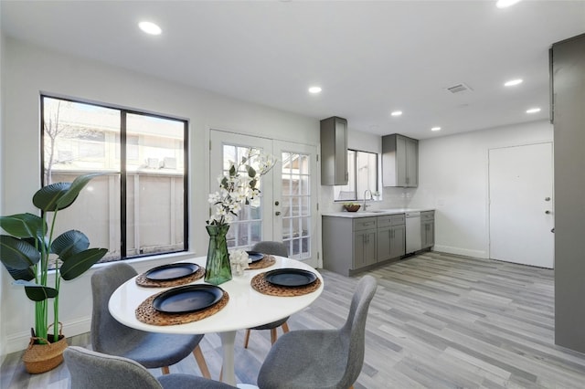 dining room featuring french doors, light hardwood / wood-style flooring, and sink