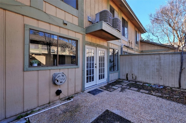 view of exterior entry featuring central AC, french doors, and a patio area