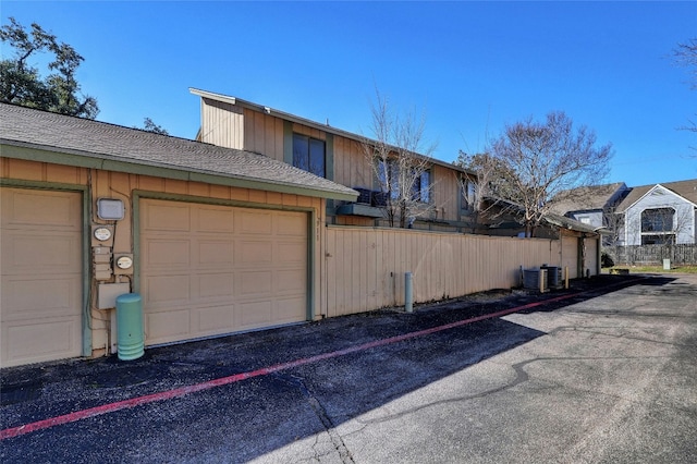 exterior space featuring a garage and cooling unit