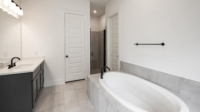 bathroom with a garden tub, vanity, baseboards, tile patterned floors, and a stall shower