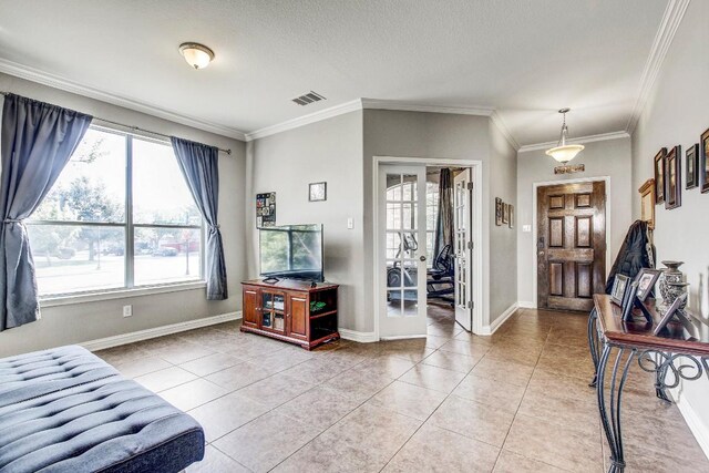 tiled foyer entrance with a textured ceiling, french doors, and ornamental molding