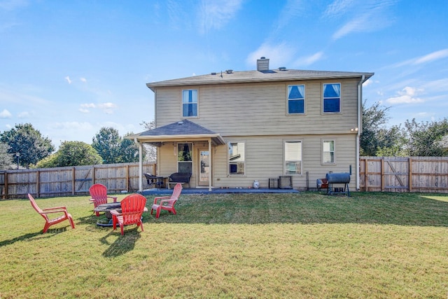 rear view of property featuring a patio and a yard