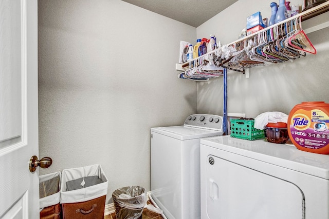 laundry room featuring washing machine and clothes dryer and a textured ceiling