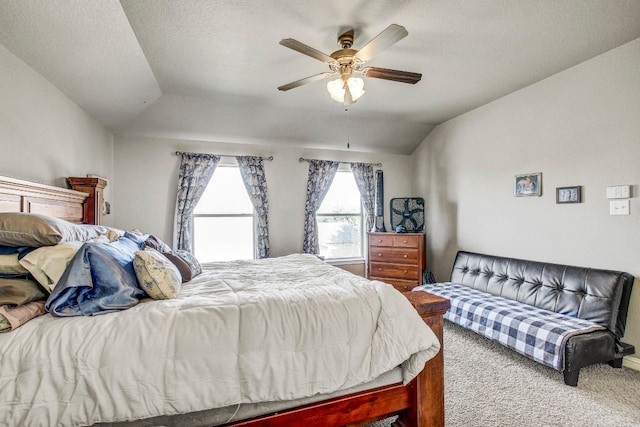 bedroom with a textured ceiling, light carpet, ceiling fan, and vaulted ceiling