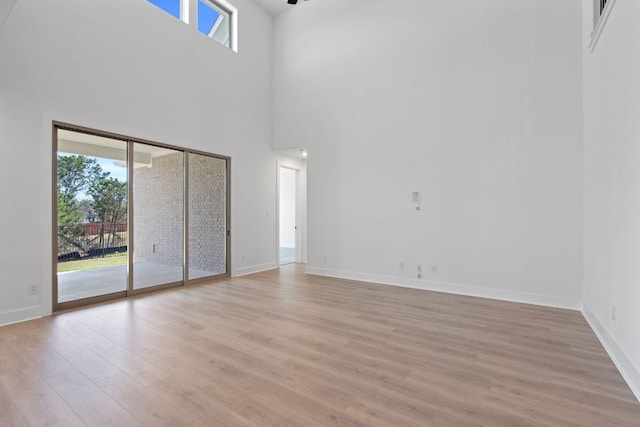 1515 Cardinal Ln, Round Rock, TX 78681 - spare room featuring light wood-style floors, baseboards, and a towering ceiling