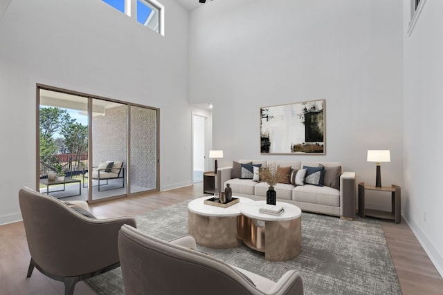 1515 Cardinal Ln, Round Rock, TX 78681 - living area with wood finished floors, a towering ceiling, and baseboards