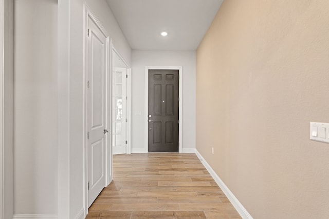 corridor with light hardwood / wood-style flooring