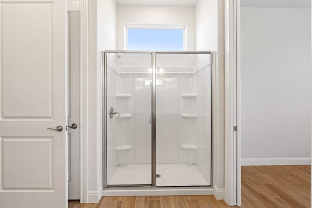 bathroom with hardwood / wood-style flooring and walk in shower