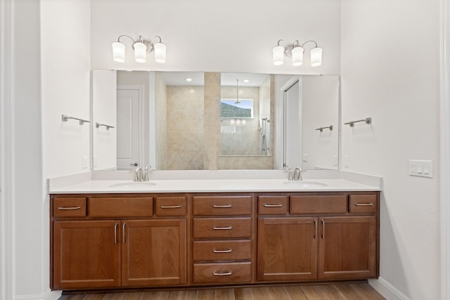 bathroom featuring hardwood / wood-style floors, vanity, and tiled shower