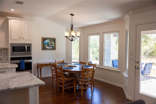 dining area featuring dark wood-type flooring, lofted ceiling, crown molding, and plenty of natural light