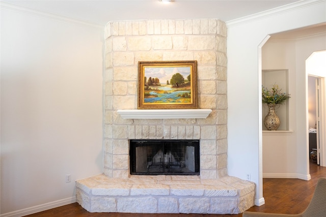 details featuring a stone fireplace, wood-type flooring, and crown molding