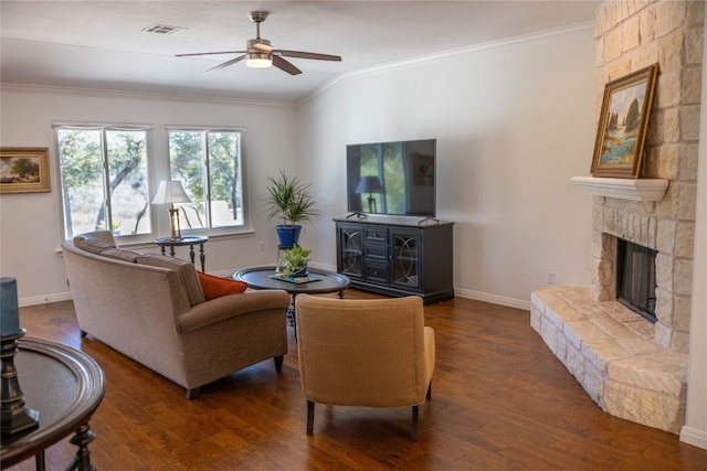 living room with a stone fireplace, ornamental molding, ceiling fan, and dark hardwood / wood-style floors