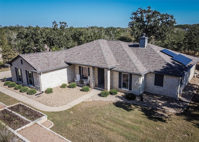 view of front of property featuring solar panels and a front lawn