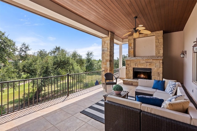 view of patio / terrace with ceiling fan and an outdoor living space with a fireplace