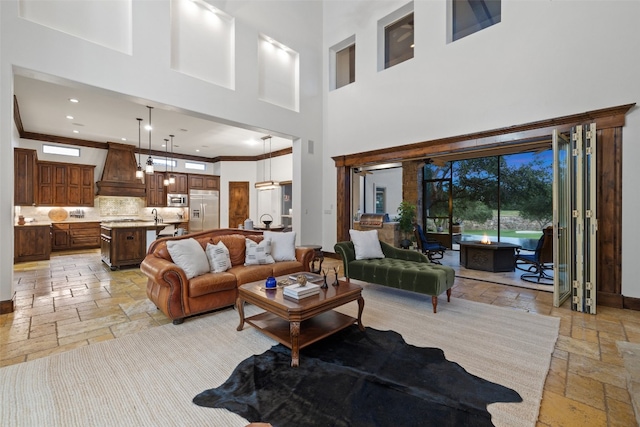 living room featuring ornamental molding and a towering ceiling