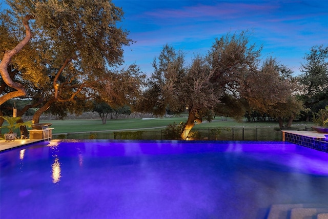 view of pool at dusk