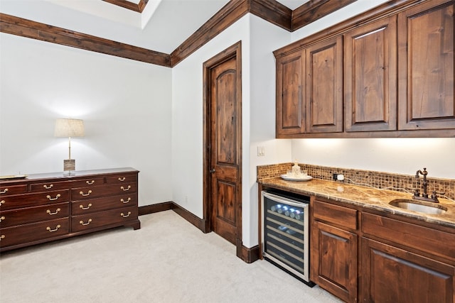 bar with stone countertops, light carpet, sink, ornamental molding, and beverage cooler