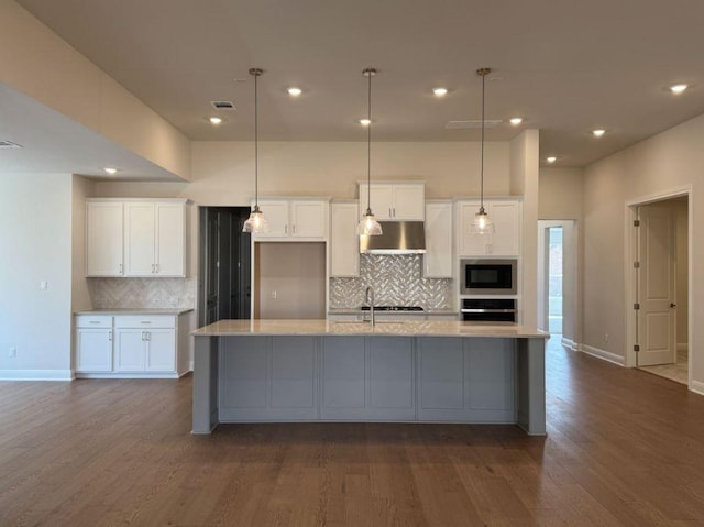 kitchen with built in microwave, wall oven, white cabinetry, and dark wood-type flooring