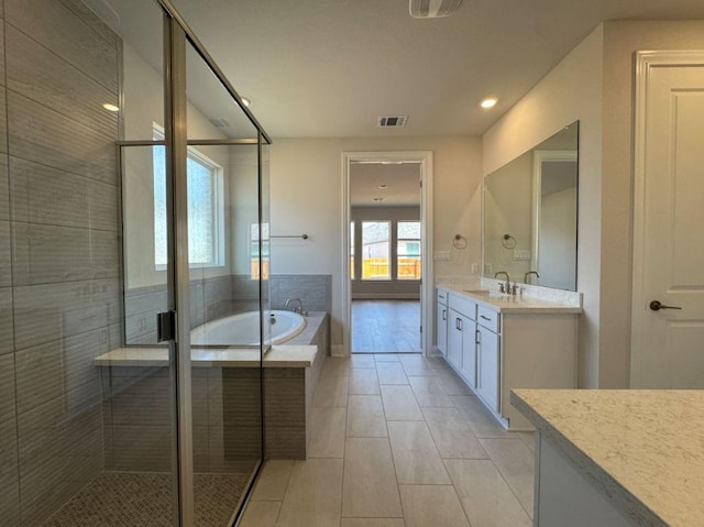 bathroom featuring tile patterned flooring, visible vents, a shower stall, a bath, and vanity