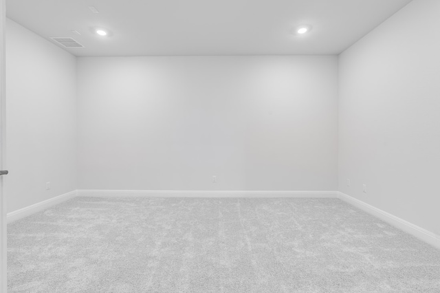 carpeted spare room featuring visible vents, recessed lighting, and baseboards