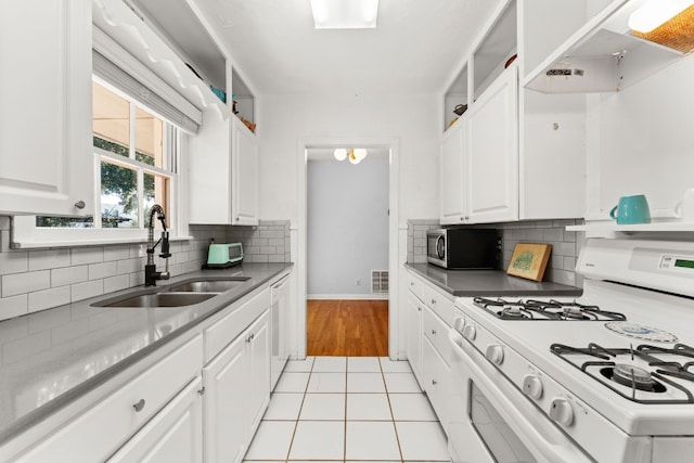 7909 Tisdale Dr, Austin, TX 78757 - kitchen with white appliances, a sink, white cabinetry, baseboards, and decorative backsplash
