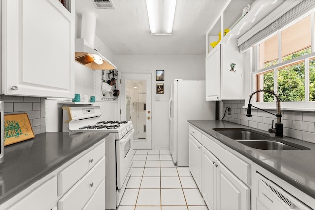 7909 Tisdale Dr, Austin, TX 78757 - kitchen featuring white appliances, wall chimney exhaust hood, white cabinetry, tasteful backsplash, and light tile patterned flooring