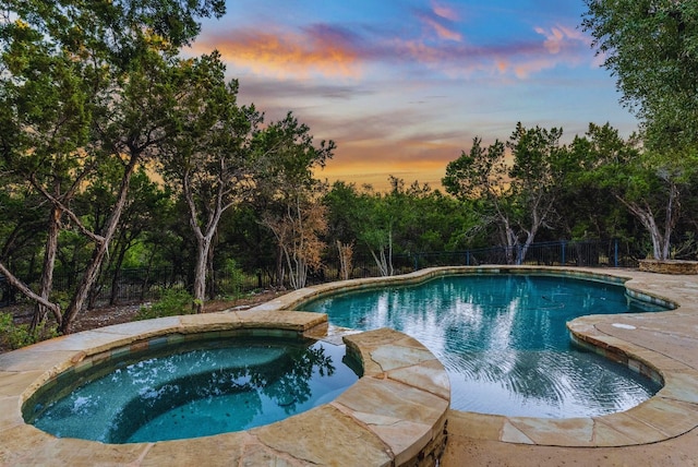 7409 Lantern View Dr, Jonestown, TX 78645 - pool at dusk with a pool with connected hot tub and view of scattered trees