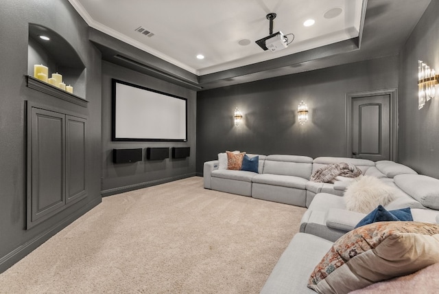 cinema featuring a raised ceiling, light carpet, and ornamental molding