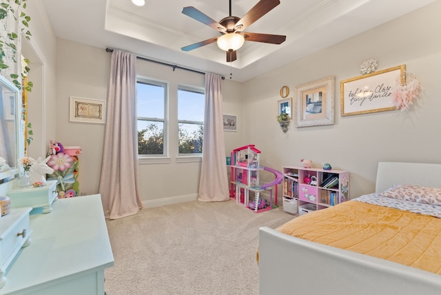 carpeted bedroom with a raised ceiling, ceiling fan, and crown molding