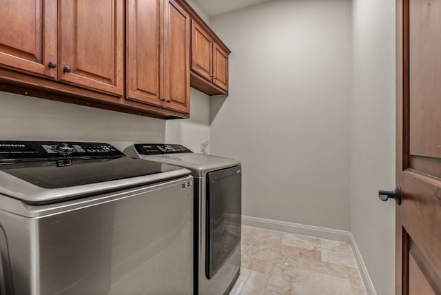 washroom with washing machine and clothes dryer and cabinets